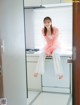 A woman sitting on top of a washing machine in a kitchen.