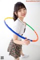 A young woman holding a hula hoop in her hands.