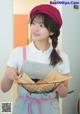 A woman in an apron holding a basket of food.