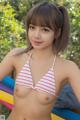 A woman in a pink and white striped bikini posing for the camera.