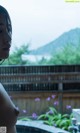 A woman standing in front of a hot tub with purple flowers.